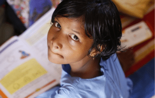 Indian Girl looking up, book in lap